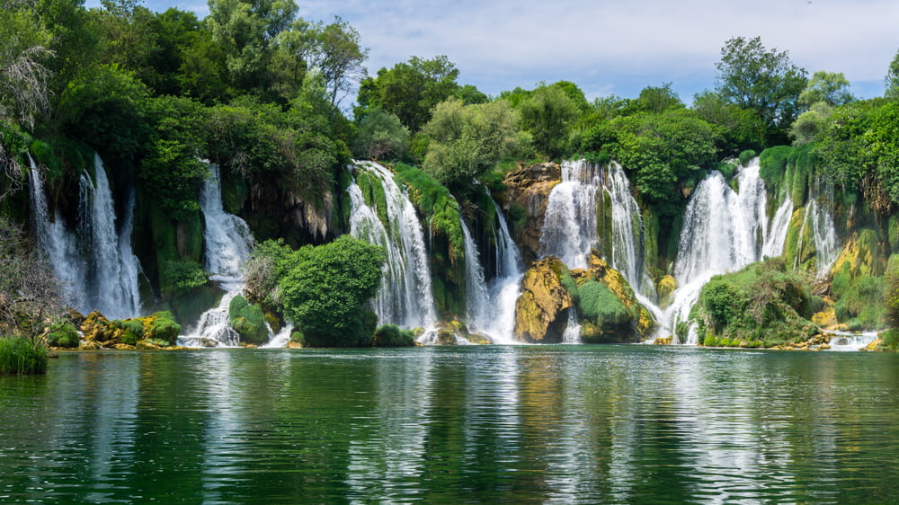small-boat-rowing-just-under-kravica-waterfalls-in-southern-_shutterstock_704552587